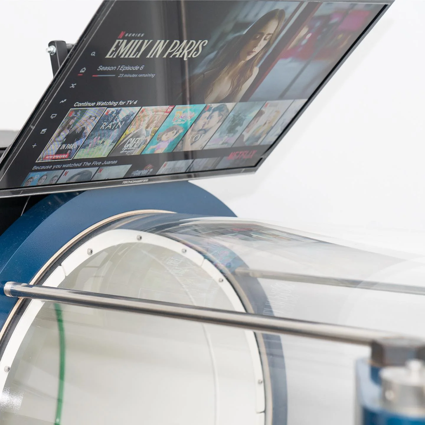 Clear acrylic hyperbaric chamber interior with a wall-mounted television above it