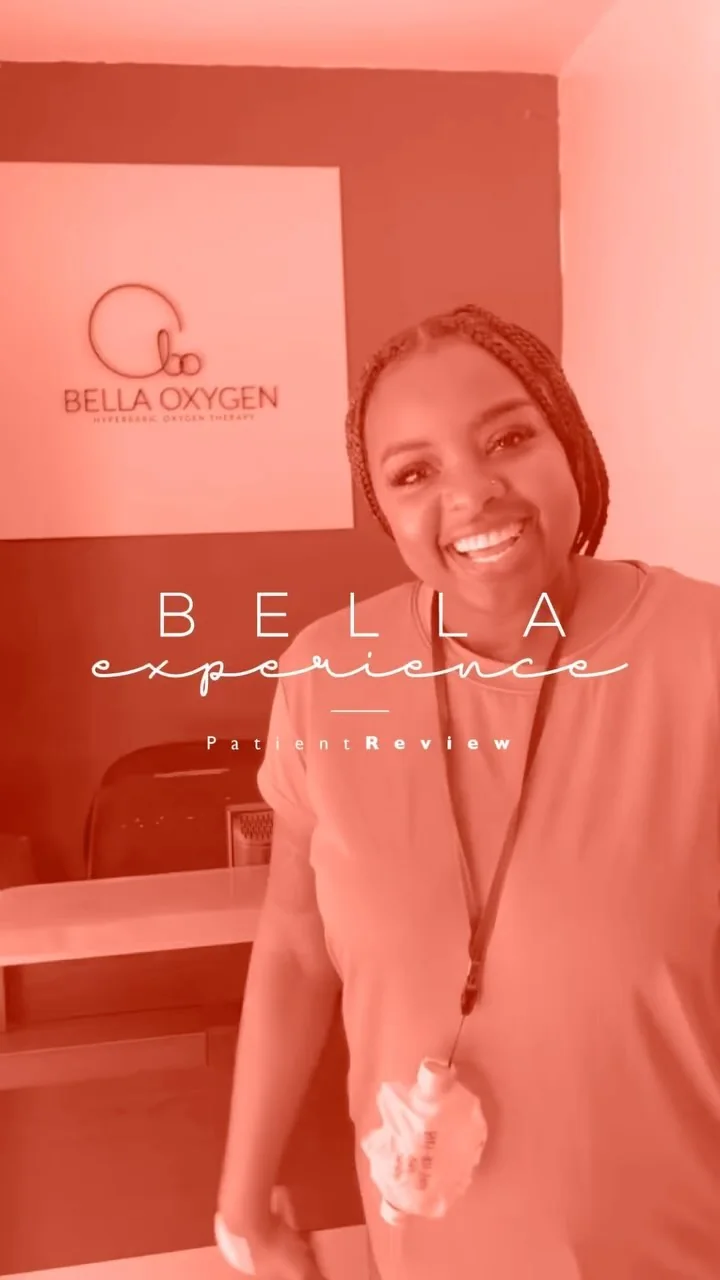 Smiling patient standing in front of the Bella Oxygen clinic wall sign